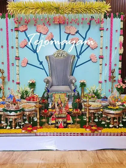A unique baby shower setup with a custom-painted backdrop featuring lotus motifs. The plate decoration in front is meticulously arranged with a variety of offerings.