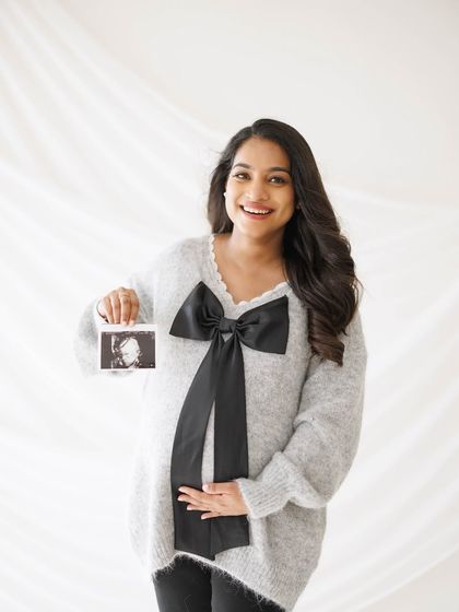 A proud mama-to-be showing off her first glimpse of baby. Including the ultrasound photo in the shoot makes the connection feel so real and immediate.