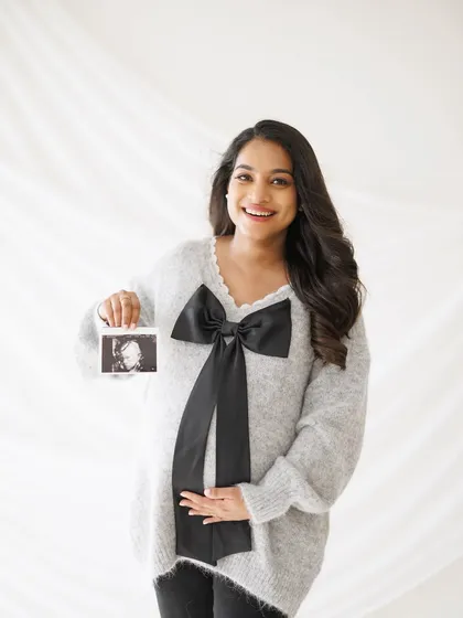 A proud mama-to-be showing off her first glimpse of baby. Including the ultrasound photo in the shoot makes the connection feel so real and immediate.