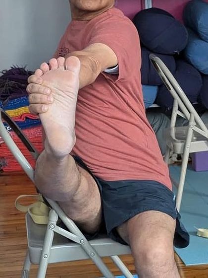 A seated leg stretch on a chair.