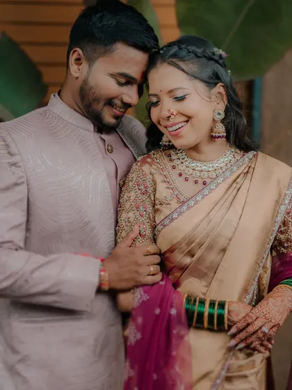 A joyful and candid moment from a traditional engagement shoot. The couple's laughter and close embrace show their happiness and excitement.