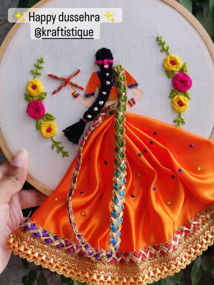 A stunning 3D embroidery hoop art celebrating the festival of Dasara. This piece combines traditional embroidery with fabric elements to create a dynamic and festive design.