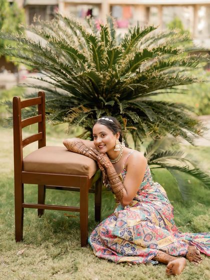 A radiant bride-to-be enjoying a moment in the garden, her intricate mehndi a part of her beautiful look.