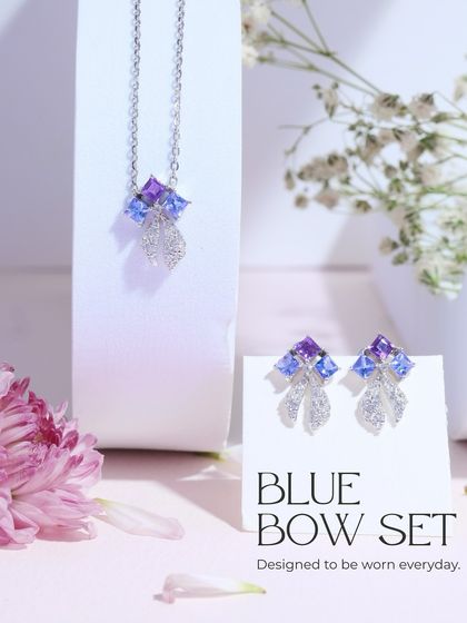 The complete Blue Bow Set, including the necklace and earrings. It's designed to be worn every day, adding a touch of cool-toned sparkle.