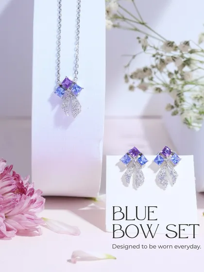 The complete Blue Bow Set, including the necklace and earrings. It's designed to be worn every day, adding a touch of cool-toned sparkle.