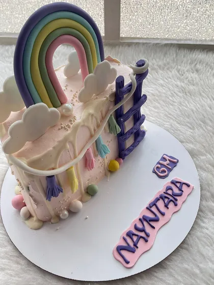 A colorful rainbow and slide-themed half-cake. This design is full of fun and playful details.