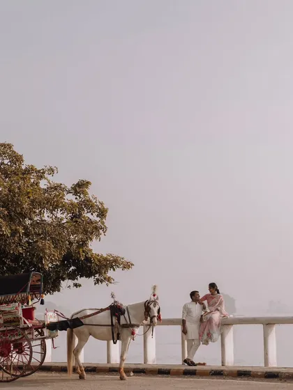A classic romantic scene by the lake in Udaipur, with a traditional horse-drawn carriage adding to the old-world charm of their pre-wedding story.