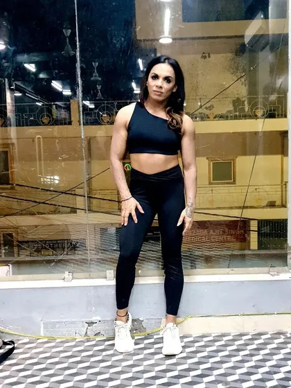 A relaxed pose at the gym. Not every photo is a flex. It's also about feeling confident and strong in your body every day, which is a core goal of my nutrition coaching.