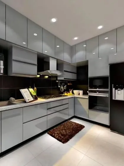 A sleek and modern kitchen with light grey glossy cabinets and integrated appliances. The black backsplash and countertop create a sharp contrast, while ample ceiling lights ensure a well-lit workspace.