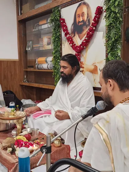 The priest leading the Rudra Puja, with a portrait of Sri Sri Ravi Shankar in the background, whose teachings inspire our studio.