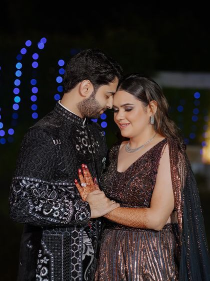 An intimate portrait of the couple against a backdrop of blue bokeh lights. Their close embrace and serene expressions make for a beautifully romantic shot.