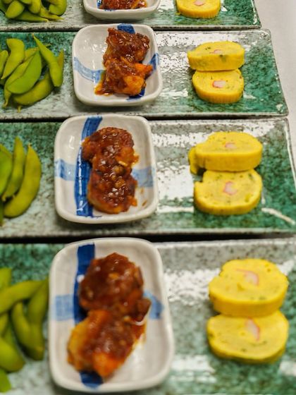 Multiple plates of our Sanmi no Kyouen appetizer, showcasing the beautiful presentation of edamame, teriyaki shrimp, and tamagoyaki.