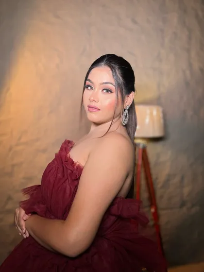 A confident look for a cocktail party. The sleek ponytail and glamorous makeup create a polished and sophisticated appearance.
