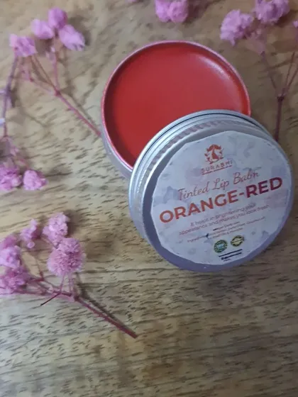 Our Orange-Red Tinted Lip Balm provides a vibrant pop of color. It's a fun and fresh shade, made with the same moisturizing, chemical-free formula.