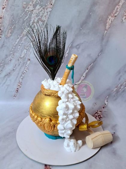 A golden matki piñata cake, ready to be smashed to reveal the treats inside.