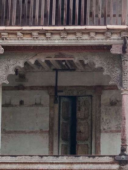 A close-up of the intricately carved wooden brackets and pillars of the Darbargarh, details we aim to salvage and restore.