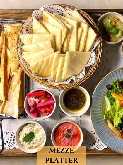 A closer look at another one of my Mezze Platters. This one includes crispy falafel, lavash sticks, a basket of pita bread, fresh salad, and a variety of dips, all arranged on a tray with delicate lace.