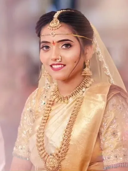 A lovely close up portrait of the bride. You can clearly see the details on the choker, the layered necklace, and the delicate maangtika and nose ring, all part of the complete bridal rental set.