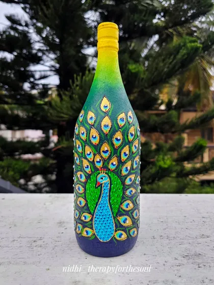 A majestic peacock with its feathers unfurled, painted on an upcycled bottle. I used rich greens, blues, and shimmering gold accents to bring this classic symbol of Indian beauty to life.