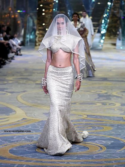 A powerful runway walk from the Manish Malhotra Bridal Couture show. The makeup was designed to be ethereal and striking, even under a delicate veil.