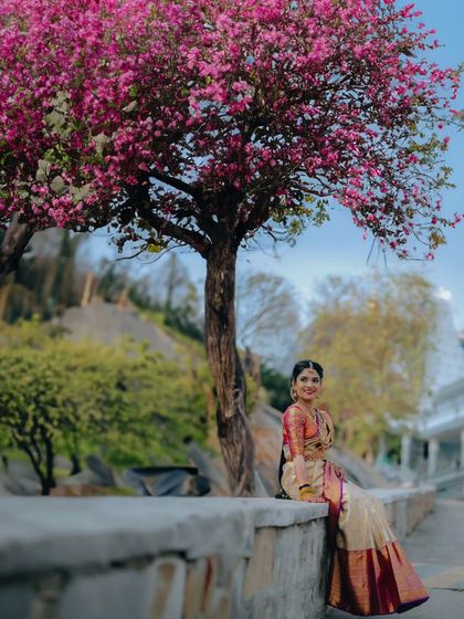 A beautiful wide-angle bridal portrait, using a blooming tree as a natural frame. This shows how we incorporate the environment to create stunning visuals.