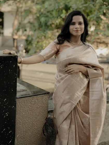 A classic and graceful portrait, showcasing the simple elegance of the saree and the subject's gentle smile.