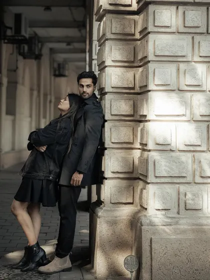 Using the strong lines and textures of Mumbai's architecture to frame the couple. This pose has a quiet, editorial feel, showcasing their connection amidst the grandeur of the city.