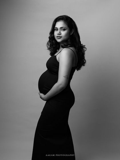 A more classic portrait pose, her expression is serene and her hands gently cradle her bump.