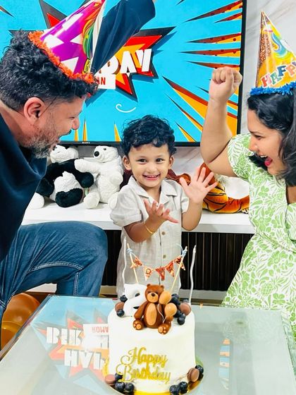 The pure joy of a birthday celebration. The birthday boy, Roman, is all smiles with his parents and his custom teddy bear cake.