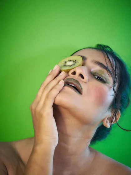 An artistic and high-fashion pose with a kiwi slice. This demonstrates my versatility, moving from commercial looks to more editorial and abstract concepts.