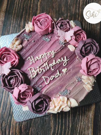 Hand-piped buttercream florals are such a joy. This square cake features a diagonal textured pattern and is framed with beautiful buttercream roses in shades of purple.