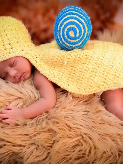 For our newborn sessions, we get creative with adorable, handmade costumes like this tiny snail outfit. Your baby will be sleeping peacefully on a soft, furry blanket while I capture their sweet, dreamy expressions in a whimsical nature-inspired setting.