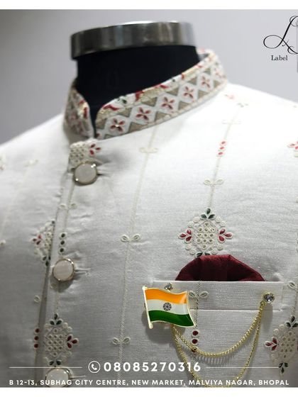 Details matter. This is a close-up of the fine embroidery and unique button work on one of my custom white Bandis. The fabric has a subtle texture, and the collar features a contrasting pattern, showing the thought that goes into every element.