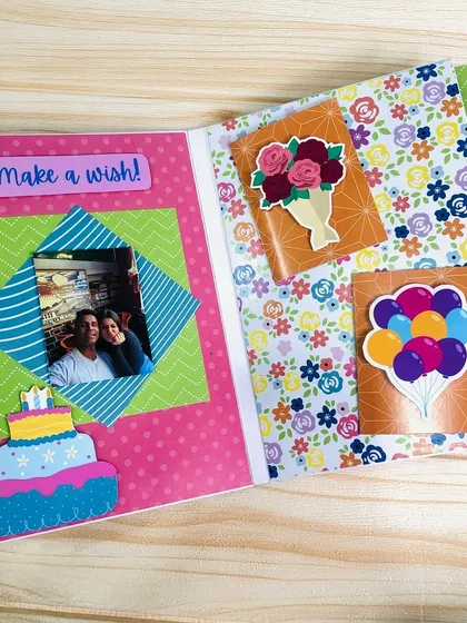 This scrapbook page has a "Make a wish!" theme, with a birthday cake sticker and pockets to hold small, surprise photos or notes.