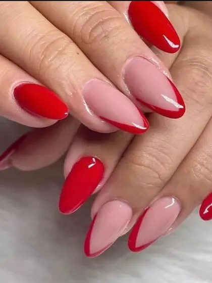 A bold and modern V-French manicure using a vibrant red polish on almond-shaped nails for a pop of color.