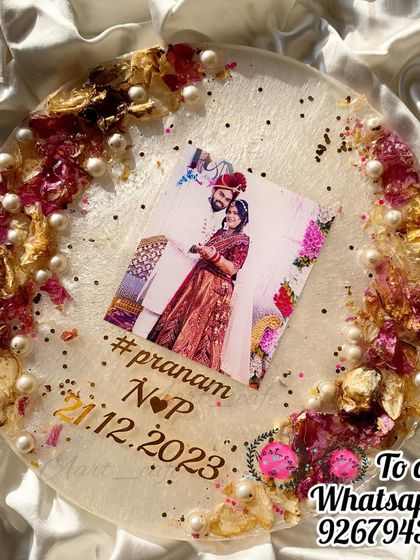 Another angle of the round resin plaque, highlighting the delicate arrangement of petals and pearls. The couple's hashtag and wedding date are inscribed, adding a personal touch.