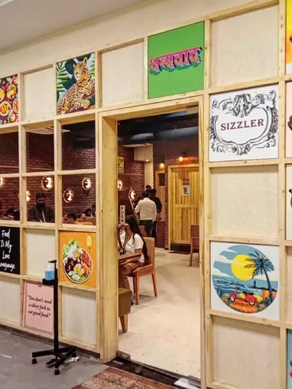 The completed art installation wall at Yoko Sizzlers, creating a fun, eclectic, and branded entryway for the restaurant.