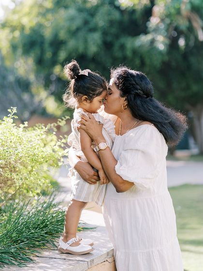 A mother and daughter sharing a sweet moment in the sun. The backlighting creates a beautiful, dreamy glow.
