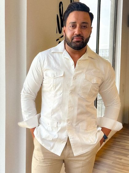 Mr. Vipul Chauhan in a custom white safari shirt and beige linen trousers, a perfect ensemble for a smart summer look.