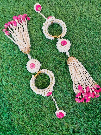 These are floral hathphool with tassels, a unique and trendy design. The combination of mogra buds and bright pink flowers is perfect for a fun Haldi or Mehendi look.