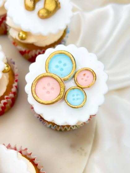 As cute as a button. This topper features a collection of pink and blue buttons with gold accents, perfect for a gender reveal or a classic baby shower theme.