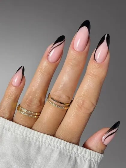 A dramatic and artistic French manicure featuring sharp, black abstract lines on a nude base for long almond nails.