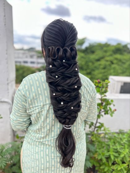 A beautiful shot of the intricate looped braid, showing its texture and the delicate pearl accessories.