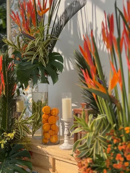 A close-up of the tropical decor, using birds of paradise, oranges, and monstera leaves for a fresh, vibrant look.
