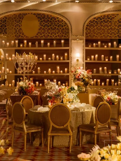 Candlelight can transform any space into a warm, intimate sanctuary. For this 'Sitara Mahal' dinner, thousands of candles illuminated the intricate mirror work and modern arches, creating a regal and unforgettable dining experience.