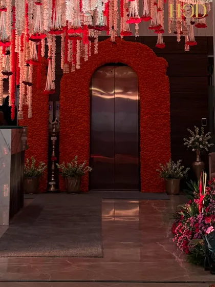 A wider perspective of the marigold-decorated entrance, showing how it integrates with the hanging floral ceiling and creates a cohesive, festive environment.