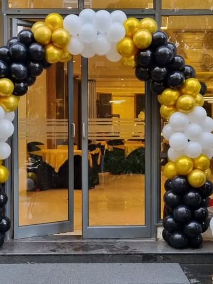 A black, white, and gold balloon arch for a football-themed 10th birthday party.