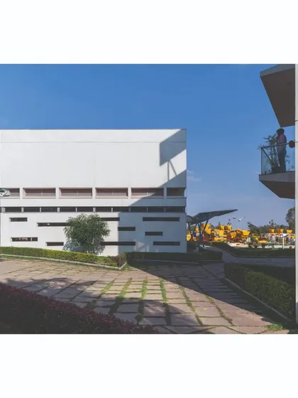 A view across a paved courtyard between two buildings at the Ajax factory. The design creates a series of "pause points" and open spaces that break up the mass of the built forms and integrate the campus seamlessly.