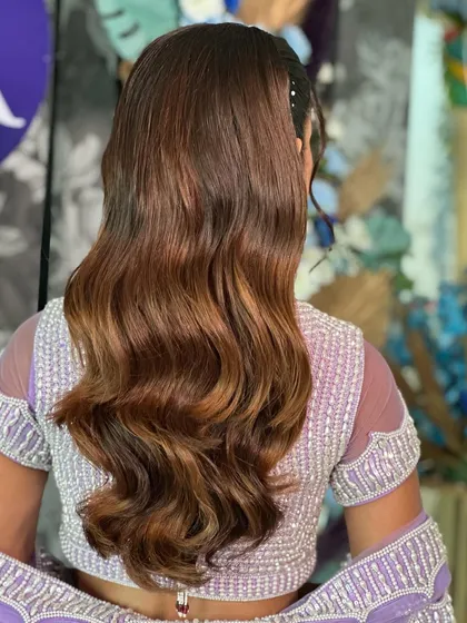 Another angle of the wavy, high-gloss ponytail, showing the beautiful dimension of the hair color and the healthy shine of the finished style.