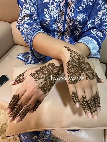 A matching set of butterfly designs on the back of the hands. This symmetrical and modern pattern is great for parties or for those who prefer a less traditional look.